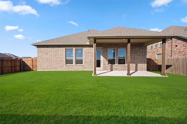 back of house featuring a lawn and a patio