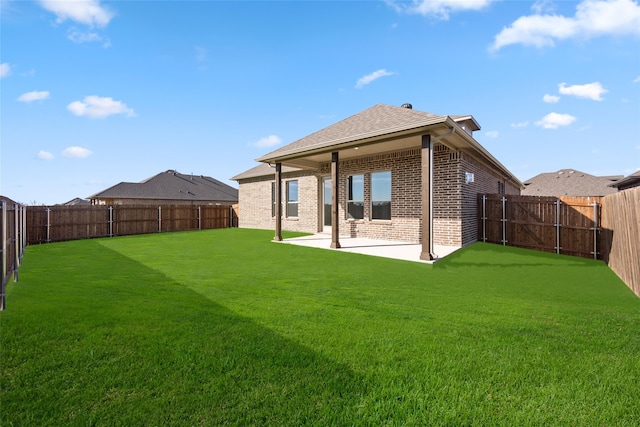 back of property with a yard and a patio