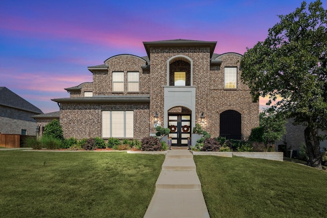 view of front facade with french doors and a lawn