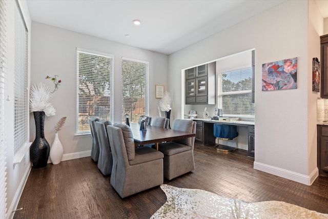 dining space with dark hardwood / wood-style flooring, built in desk, and a wealth of natural light