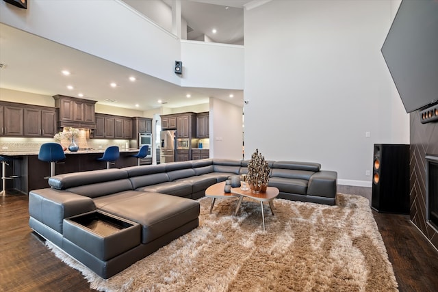 living room with high vaulted ceiling and dark wood-type flooring