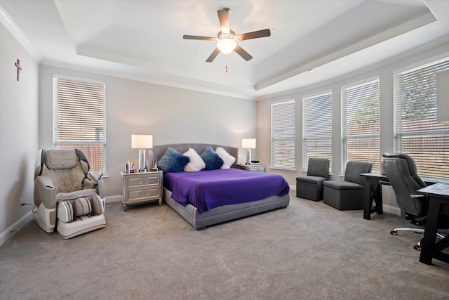 bedroom with carpet floors, a tray ceiling, and ceiling fan