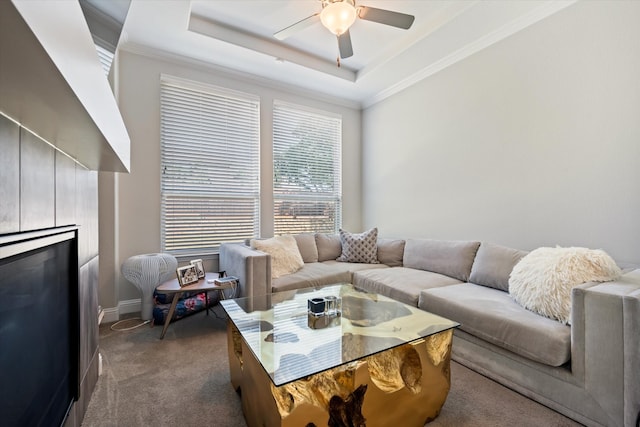 carpeted living room with crown molding, ceiling fan, and a raised ceiling