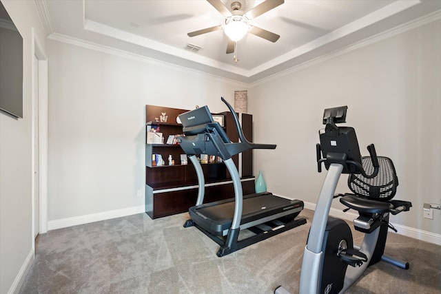 workout area featuring crown molding, a raised ceiling, light carpet, and ceiling fan