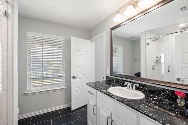 bathroom with vanity, tiled shower, tile patterned flooring, and toilet