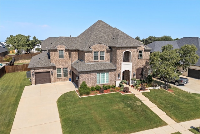 french provincial home featuring a front yard and a garage