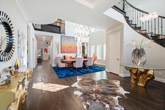 entryway featuring ornamental molding, dark hardwood / wood-style flooring, and a high ceiling