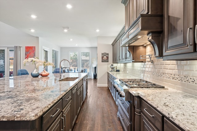 kitchen featuring light stone countertops, sink, appliances with stainless steel finishes, dark hardwood / wood-style flooring, and dark brown cabinetry