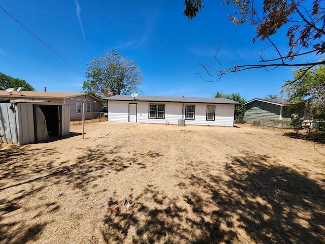 rear view of house featuring a shed