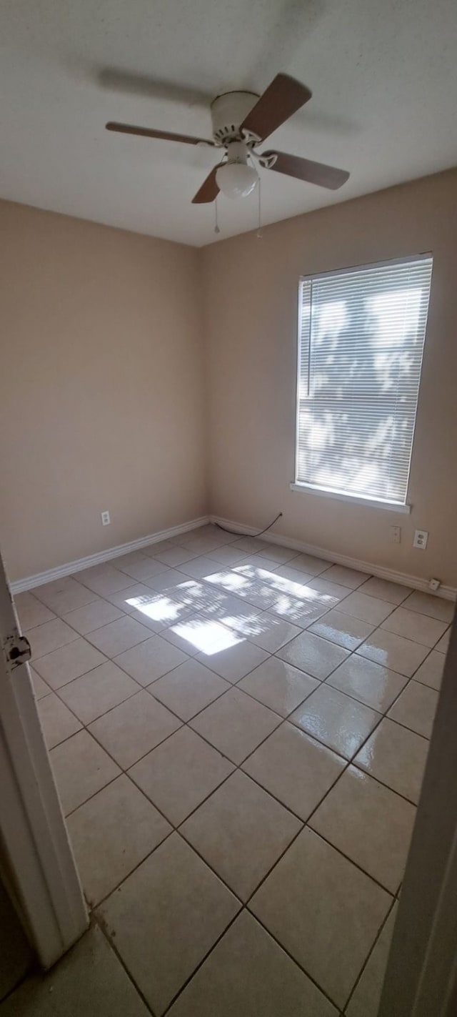 spare room featuring light tile patterned flooring and ceiling fan