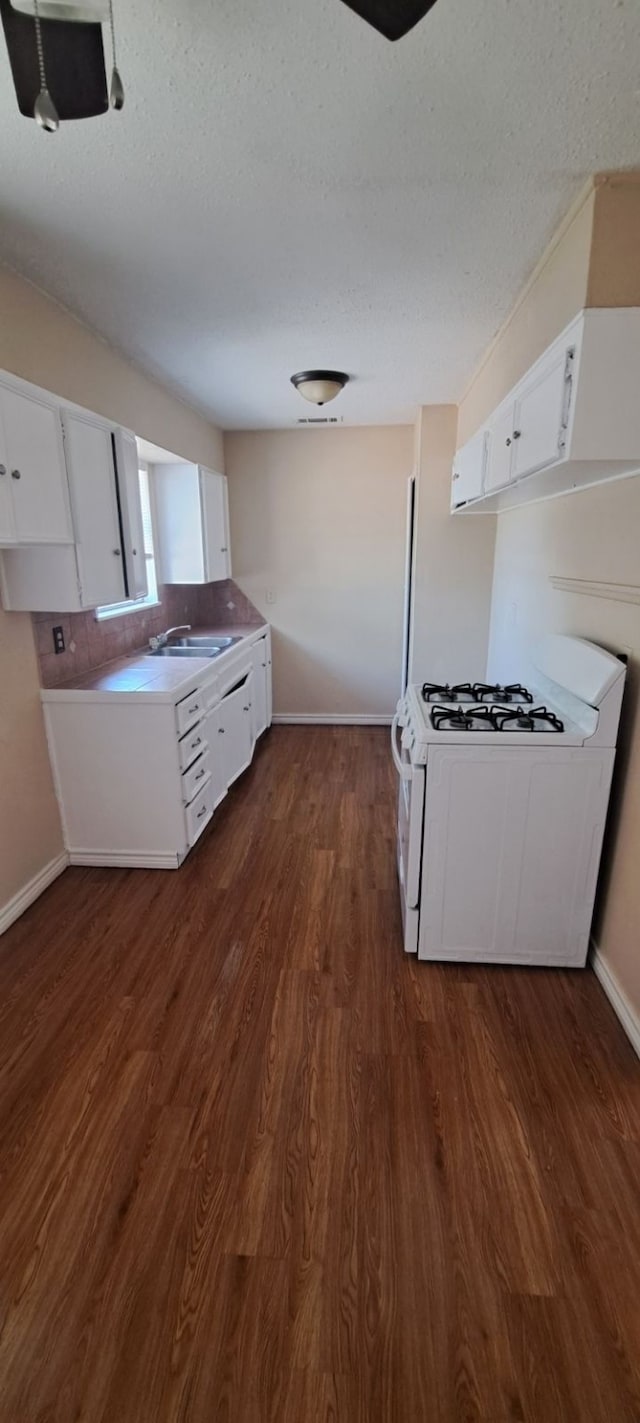 kitchen with sink, white range with gas cooktop, dark hardwood / wood-style floors, and white cabinetry