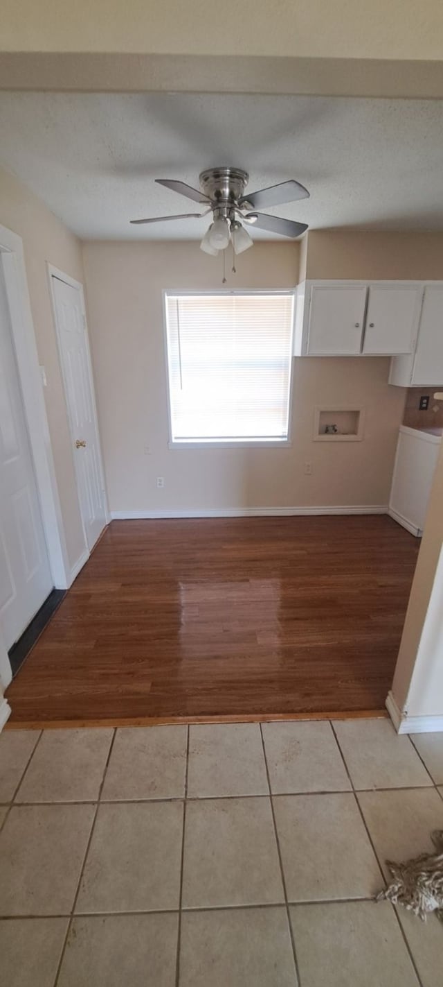 interior space featuring white cabinetry, light hardwood / wood-style floors, and ceiling fan