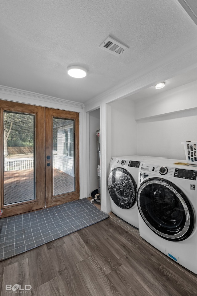 laundry area featuring washing machine and dryer, french doors, a textured ceiling, dark wood-type flooring, and crown molding