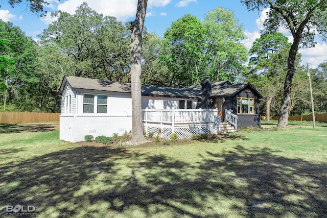 view of front of property with a deck, brick siding, fence, crawl space, and a front lawn