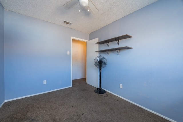 empty room featuring dark carpet, a textured ceiling, and ceiling fan