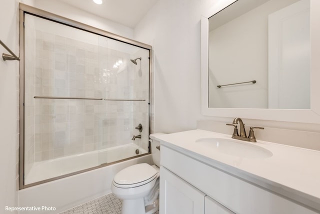 full bathroom featuring toilet, vanity, and bath / shower combo with glass door