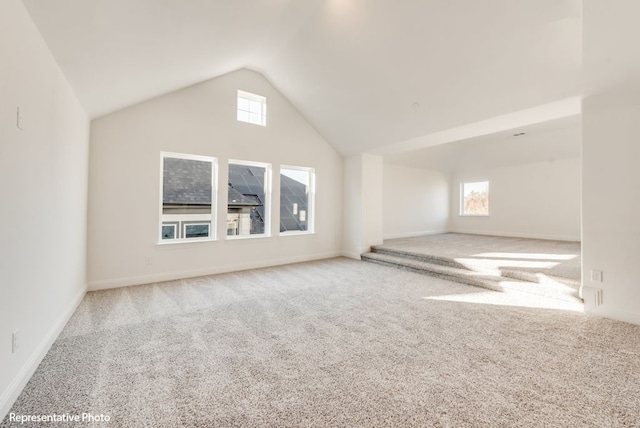 additional living space with high vaulted ceiling and carpet