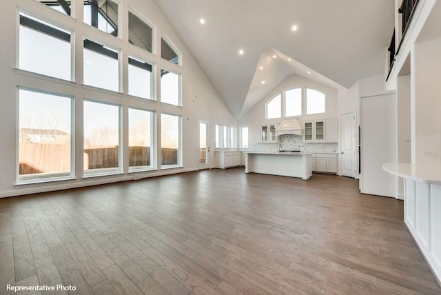 unfurnished living room with dark hardwood / wood-style floors and high vaulted ceiling