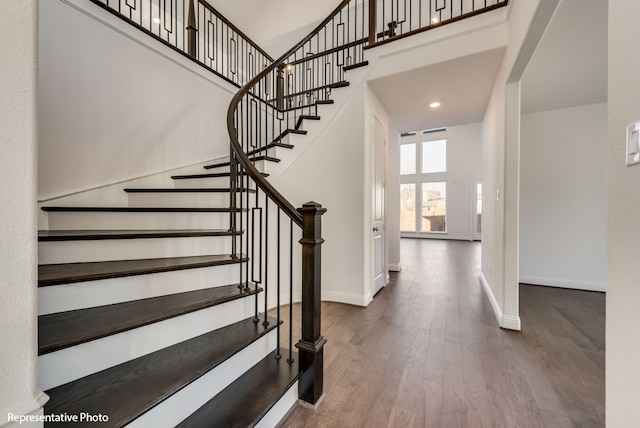 foyer entrance featuring hardwood / wood-style flooring and a towering ceiling