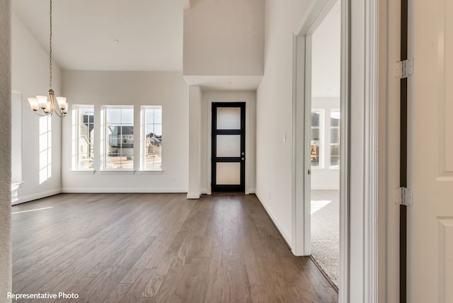 foyer featuring a healthy amount of sunlight, an inviting chandelier, and dark hardwood / wood-style flooring