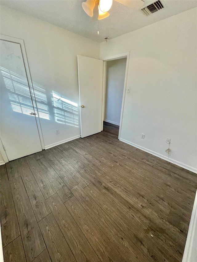 spare room with ceiling fan, dark hardwood / wood-style flooring, and a textured ceiling