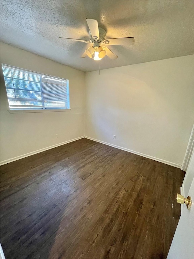 empty room featuring ceiling fan, dark hardwood / wood-style floors, and a textured ceiling