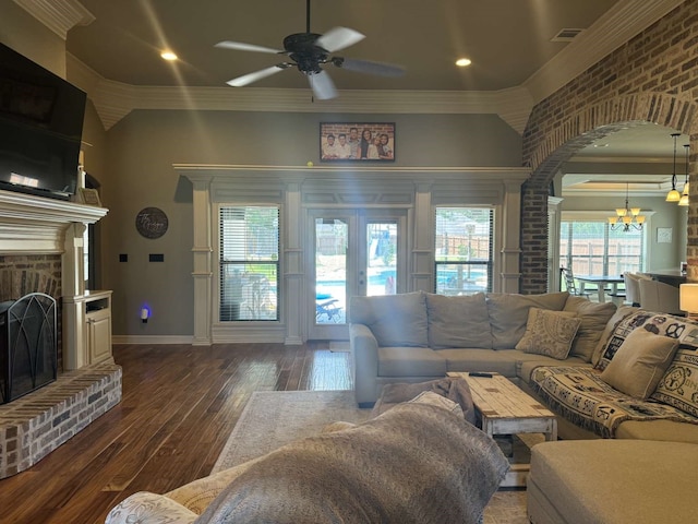 living room featuring ornamental molding, ceiling fan with notable chandelier, and dark hardwood / wood-style flooring