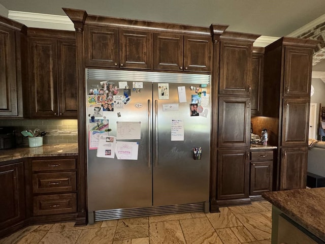 kitchen with crown molding, dark brown cabinetry, and built in fridge