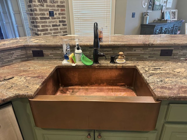 interior details featuring sink, backsplash, and green cabinets