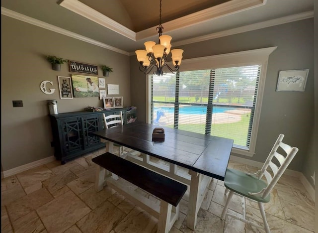 dining room with ornamental molding, an inviting chandelier, and a raised ceiling