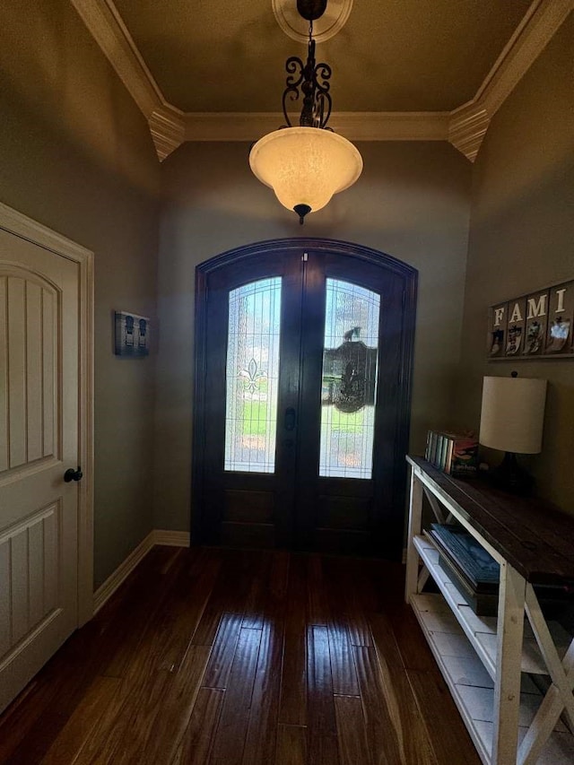 foyer featuring dark wood-type flooring, crown molding, and french doors