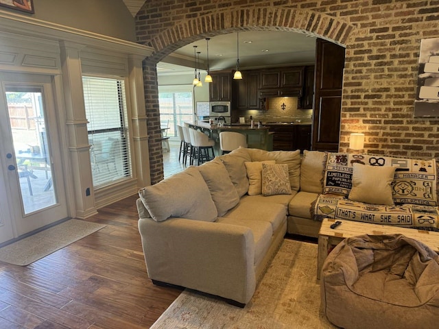 living room featuring brick wall and wood-type flooring