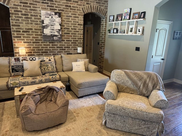 living room featuring brick wall and hardwood / wood-style floors