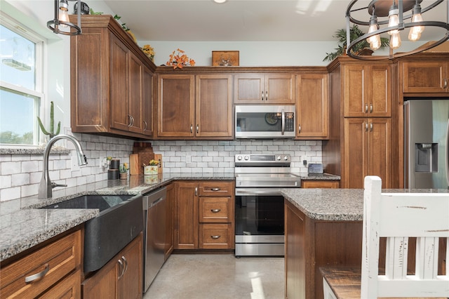 kitchen featuring a healthy amount of sunlight, hanging light fixtures, appliances with stainless steel finishes, and a chandelier