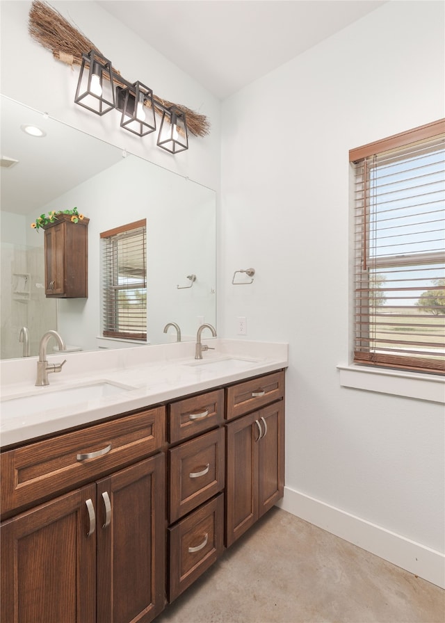 bathroom featuring concrete floors, vanity, and a healthy amount of sunlight