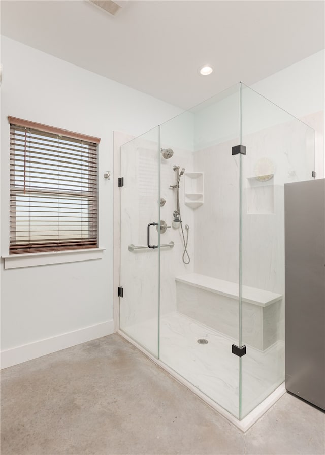 bathroom with walk in shower and concrete floors