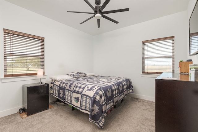 carpeted bedroom featuring multiple windows and ceiling fan