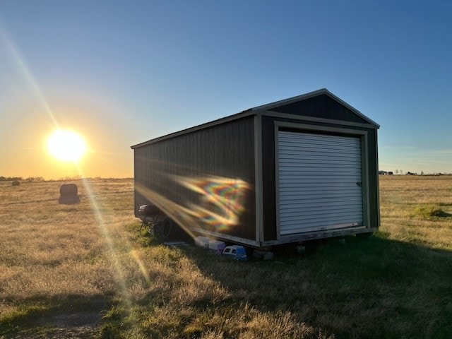 view of outbuilding featuring a yard and a rural view