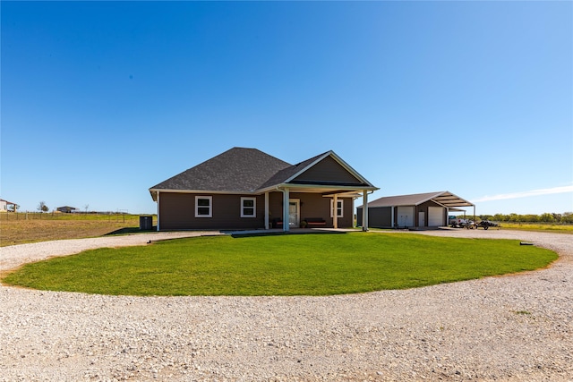 view of front of house featuring an outbuilding, covered porch, a front yard, and a garage