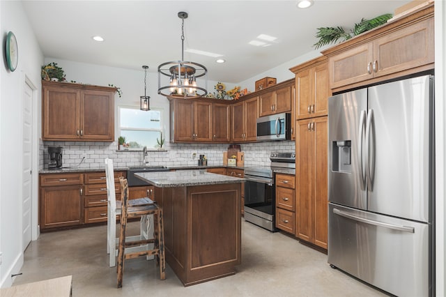 kitchen featuring a center island, hanging light fixtures, tasteful backsplash, a notable chandelier, and appliances with stainless steel finishes