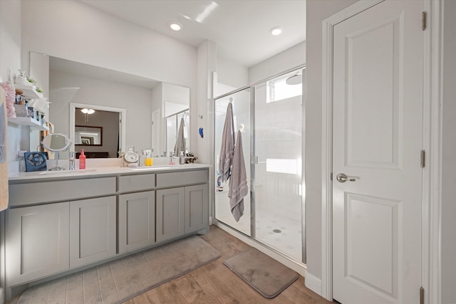 bathroom with vanity, a shower with shower door, and wood-type flooring