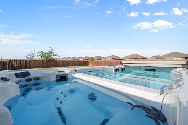 view of pool with a hot tub