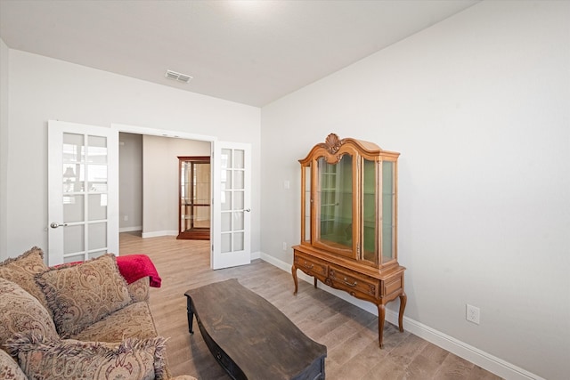 living area featuring french doors and light hardwood / wood-style flooring