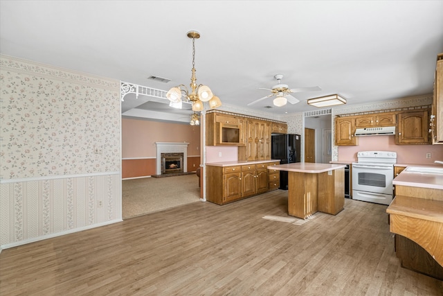 kitchen with a kitchen island, black refrigerator, pendant lighting, light hardwood / wood-style floors, and electric stove