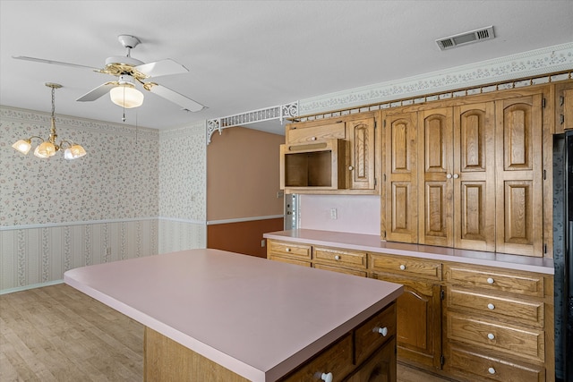 kitchen with ceiling fan with notable chandelier, light hardwood / wood-style floors, decorative light fixtures, and a kitchen island