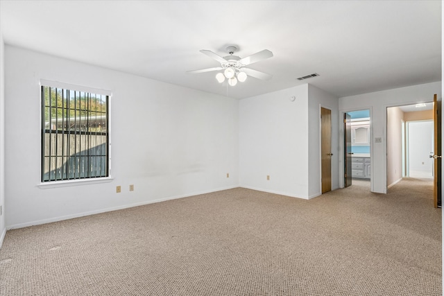 spare room featuring light colored carpet and ceiling fan