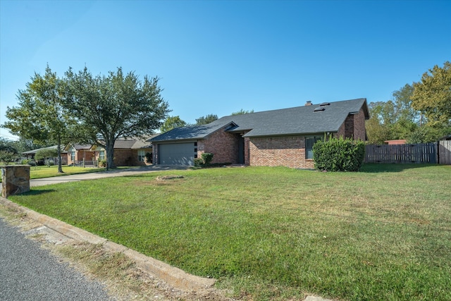 single story home featuring a front lawn and a garage