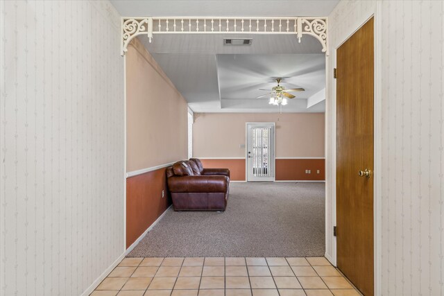 unfurnished room featuring ceiling fan, a raised ceiling, and light colored carpet