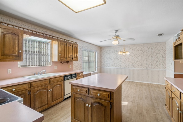 kitchen with white dishwasher, sink, light wood-type flooring, and a kitchen island