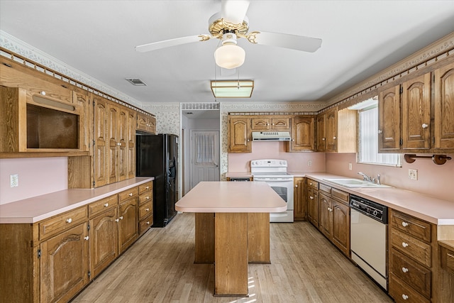 kitchen featuring a kitchen island, light hardwood / wood-style flooring, sink, white appliances, and ceiling fan